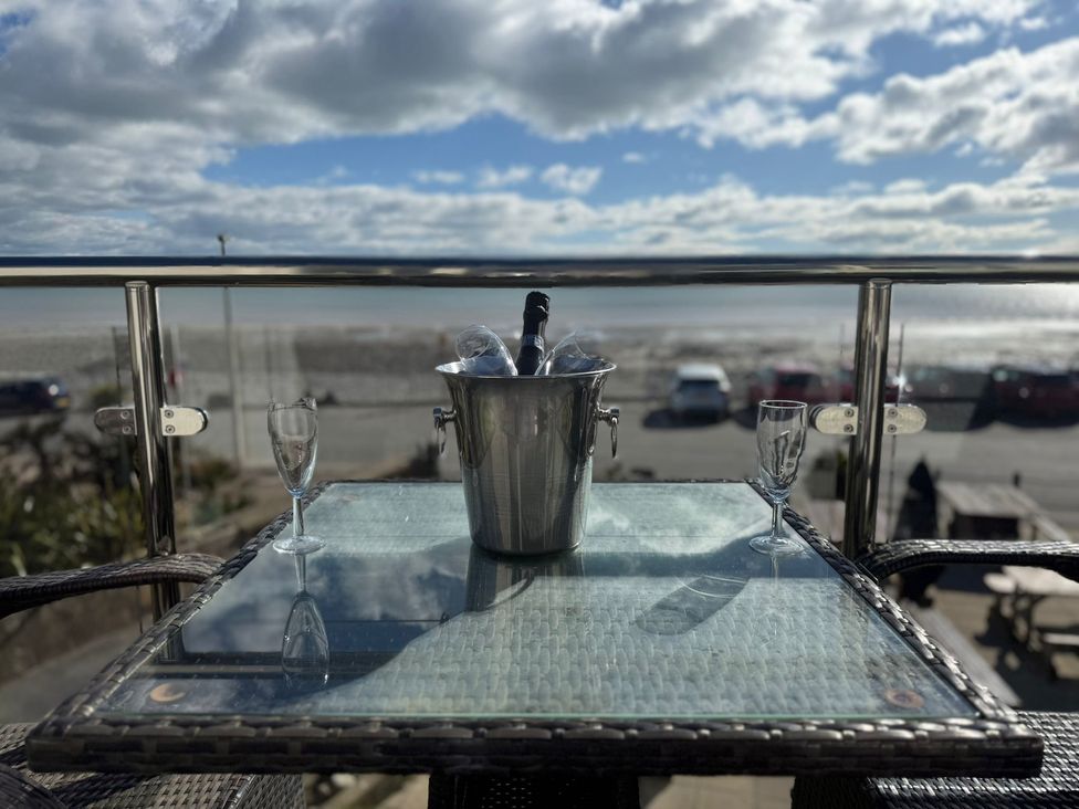 A table with glasses and an ice bucket overlooking the sea at The Cartwheel in Amroth