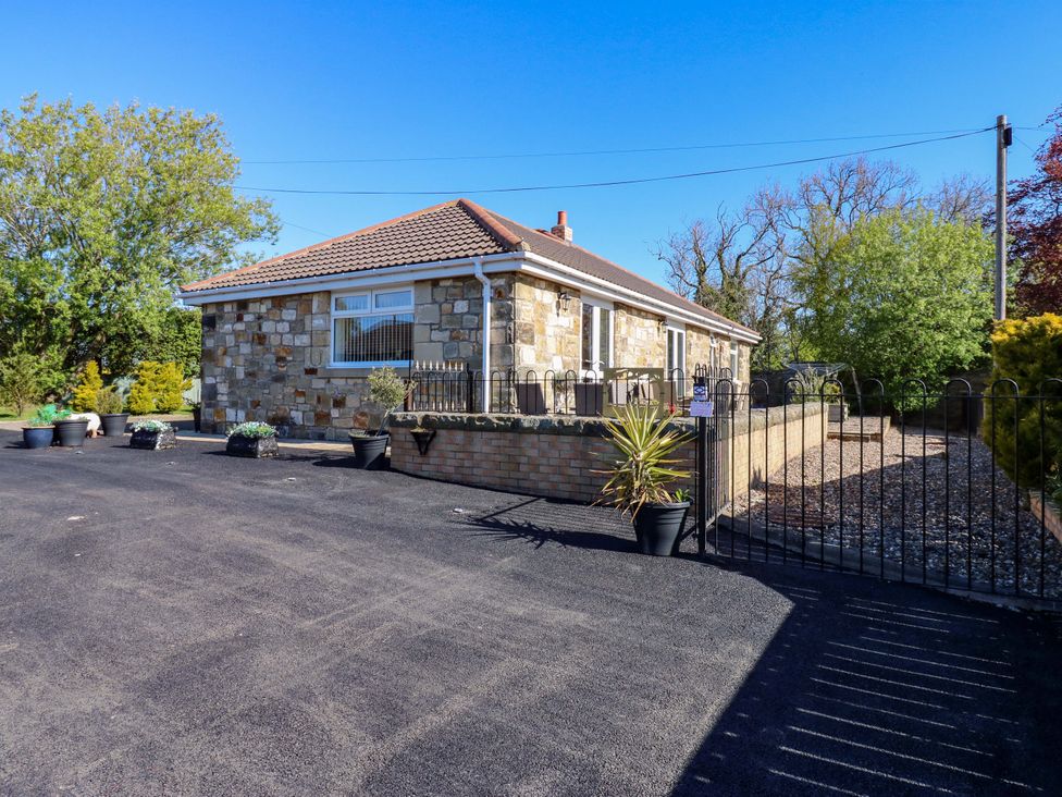 A house with stone exterior and driveway at Blacksmiths Cottage in Shilbottle
