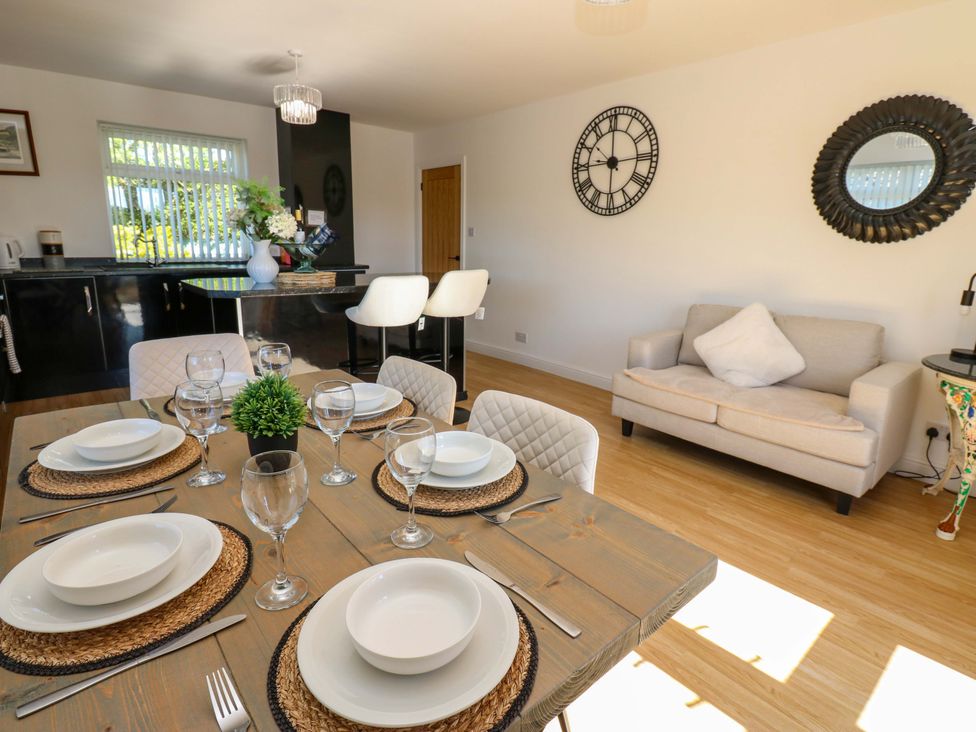 A dining room with a table set for dinner at Blacksmiths Cottage Shilbottle