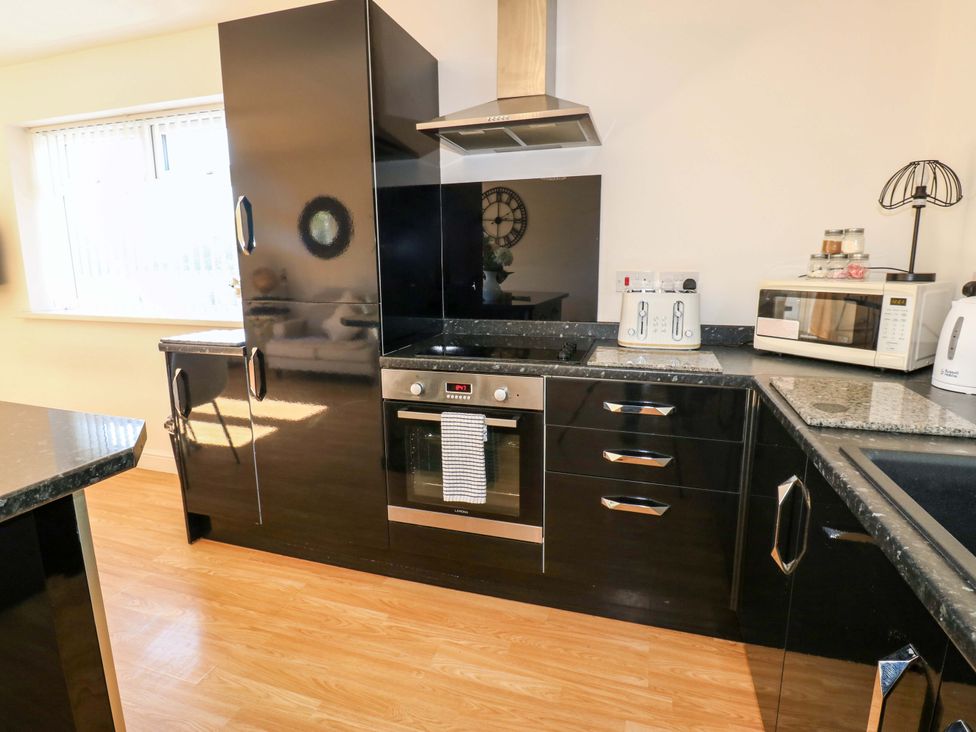 A kitchen with appliances and countertop at Blacksmiths Cottage in Shilbottle