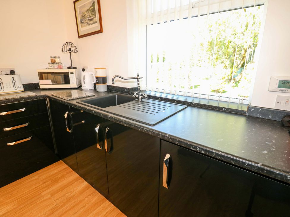 A kitchen with a sink and countertop at Blacksmiths Cottage in Shilbottle