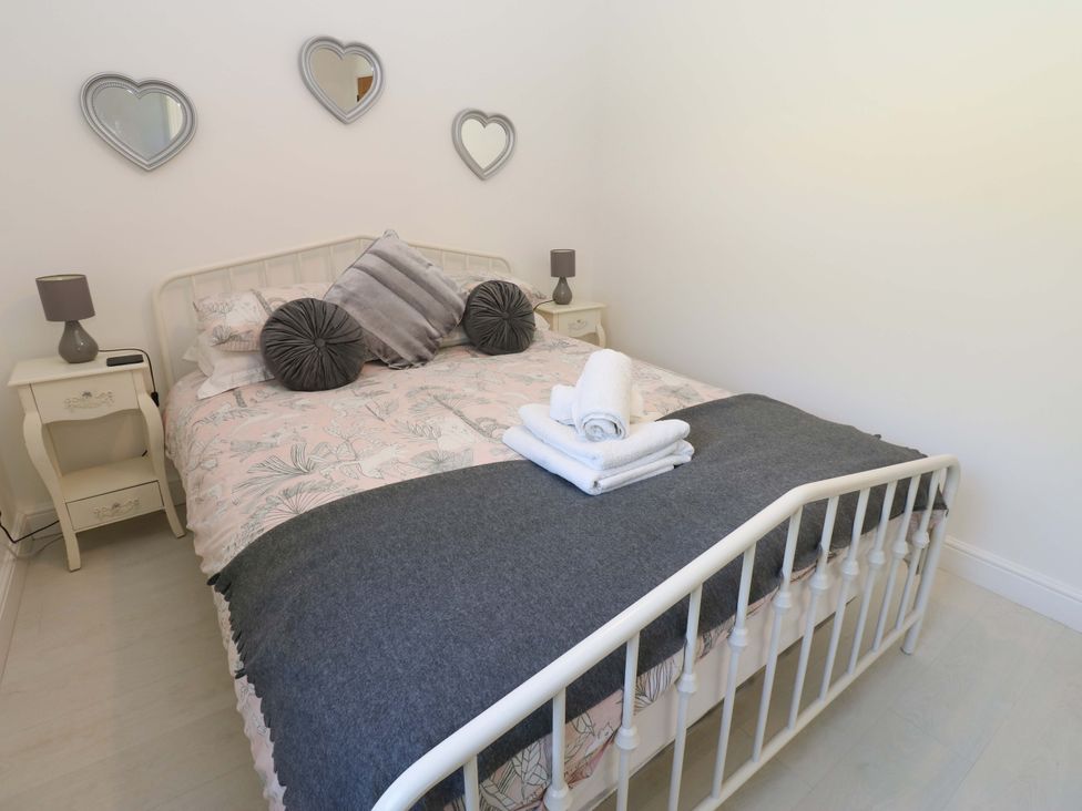 A bedroom with a bed and bedside tables at Blacksmiths Cottage in Shilbottle