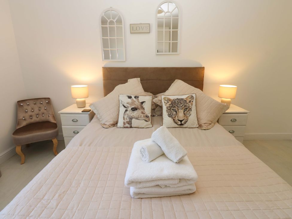 A bedroom with a bed and decorative pillows at Blacksmiths Cottage in Shilbottle