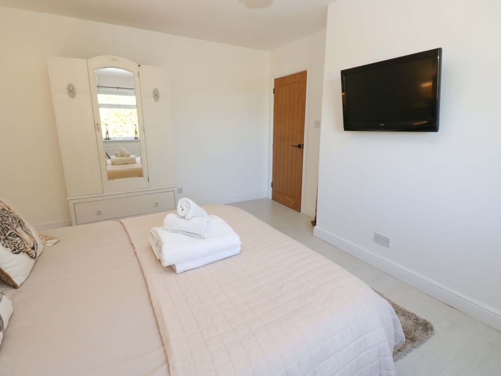 A bedroom with a bed and wardrobe at Blacksmiths Cottage in Shilbottle
