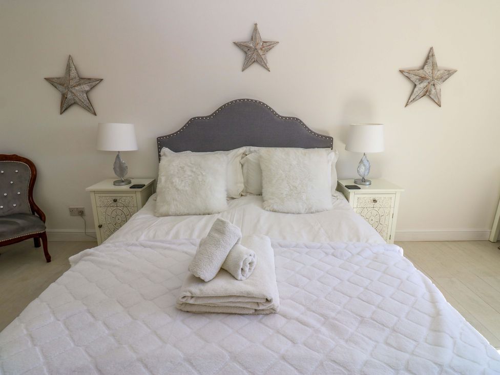 A bedroom with a bed and decorative elements at Blacksmiths Cottage in Shilbottle