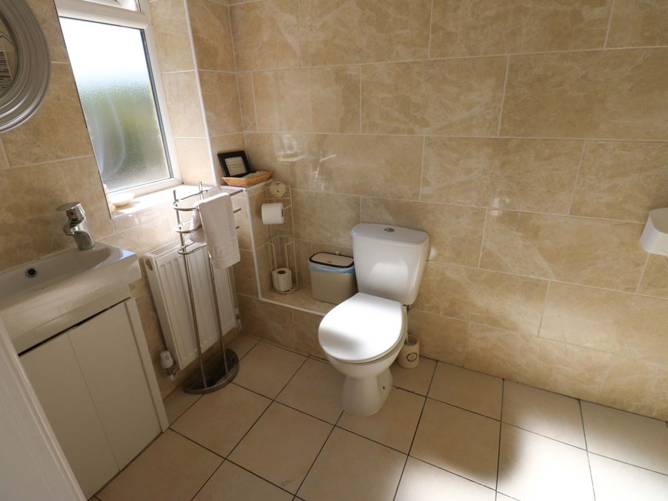 A bathroom with a toilet and sink at Blacksmiths Cottage in Shilbottle