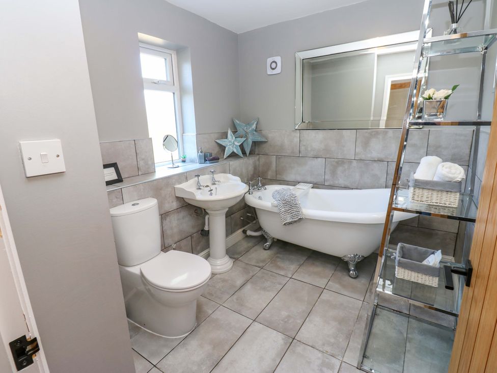 A bathroom with a sink toilet and bath tub at Blacksmiths Cottage in Shilbottle