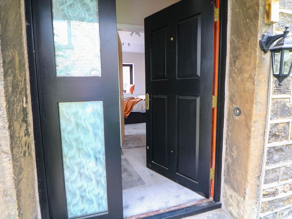 An entrance view showing an open front door with a carpet at Half Under
