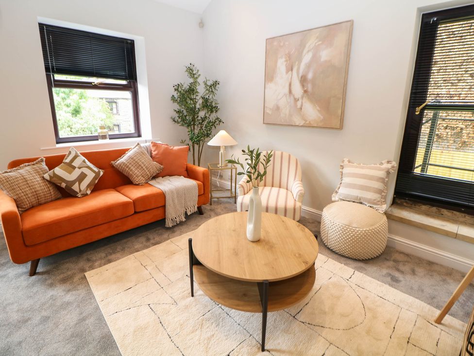 A living room with an orange sofa and a coffee table at Half Under