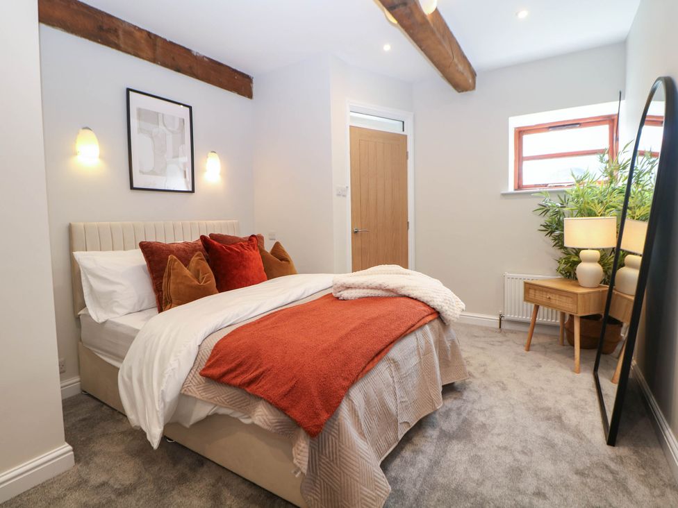 A bedroom with a bed and bedside table at Half Under