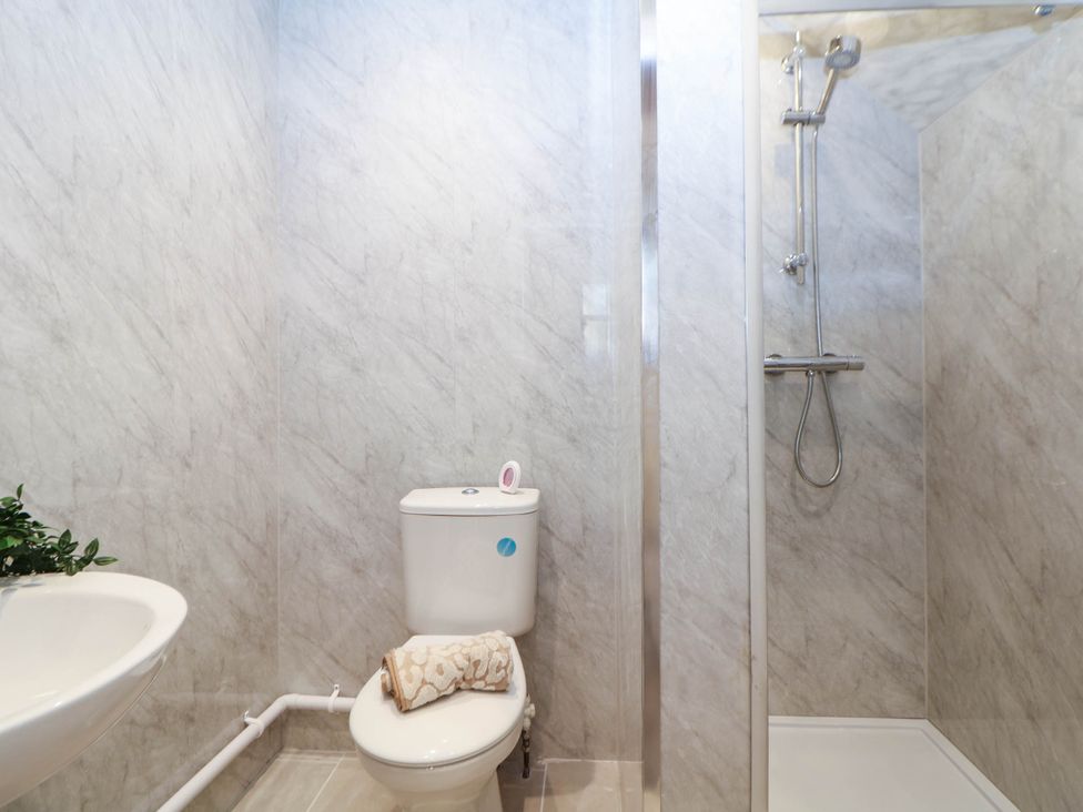 A bathroom with a shower, toilet, and sink at Half Under