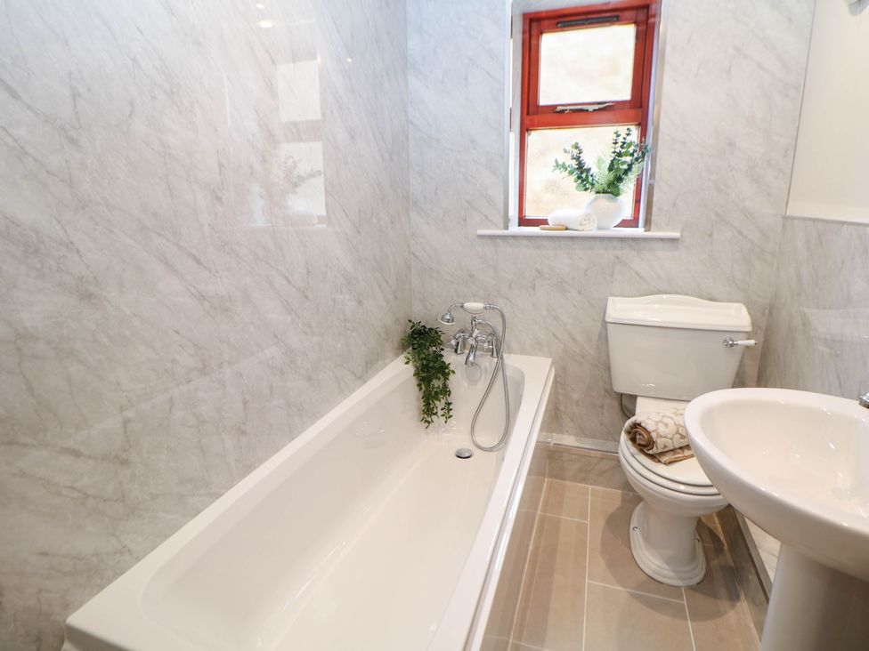 A bathroom with a bathtub, toilet, and sink at Half Under