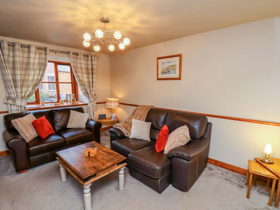 A living room with a sofa and coffee table at Eskview Cottage in Ruswarp near Whitby