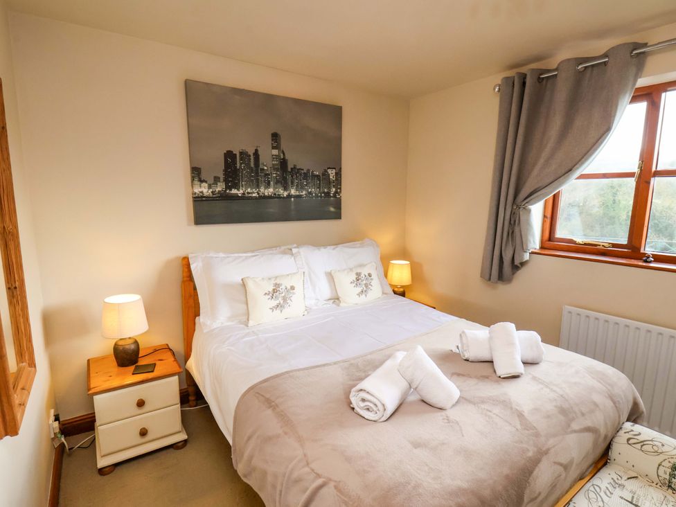 A bedroom with a bed and bedside table at Eskview Cottage in Ruswarp near Whitby
