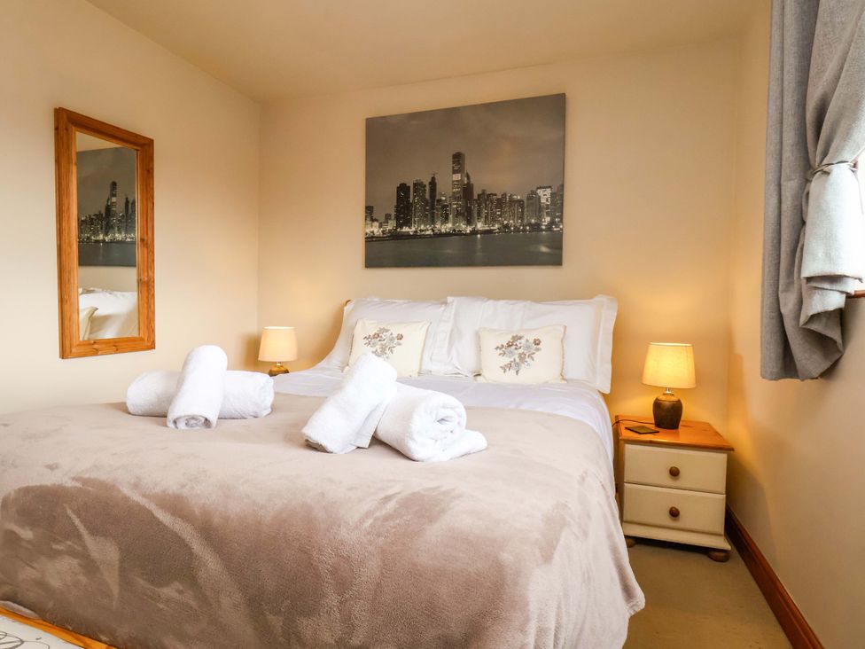 A bedroom with a bed and wall art at Eskview Cottage in Ruswarp near Whitby