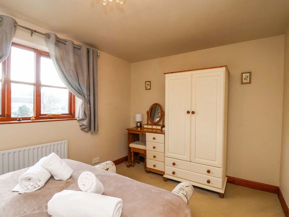 A bedroom with a bed and wardrobe at Eskview Cottage in Ruswarp near Whitby