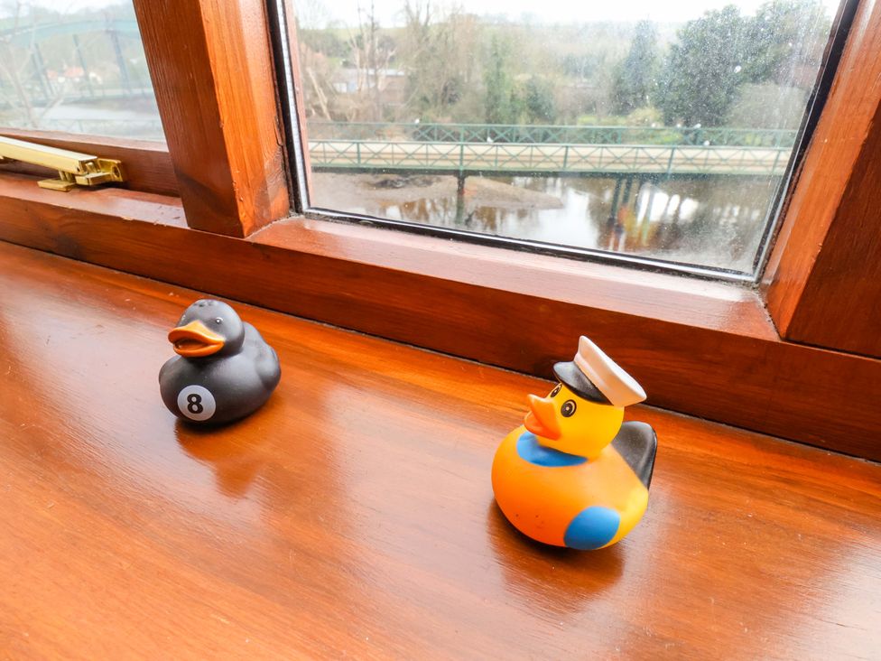 Two rubber ducks on a wooden surface near a window at Eskview Cottage in Ruswarp near Whitby