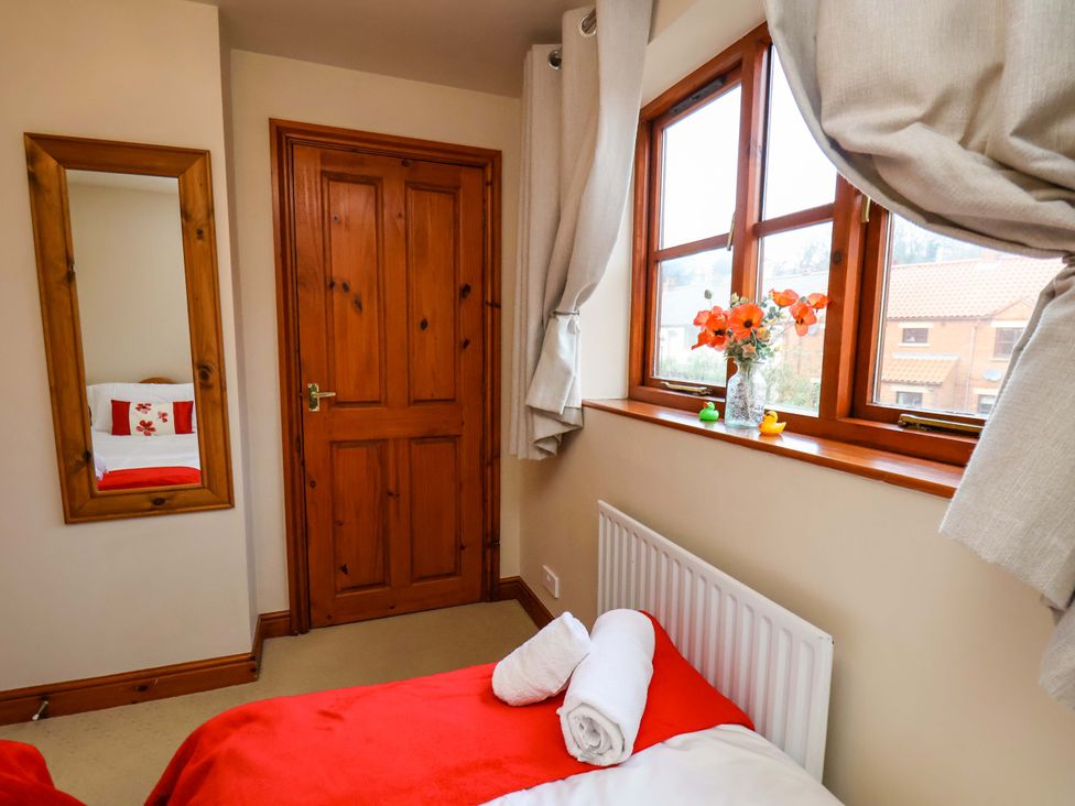 A bedroom with a bed and window at Eskview Cottage in Ruswarp near Whitby