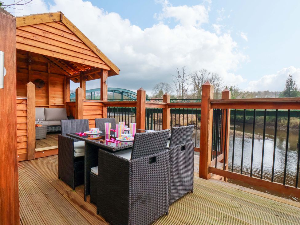 An outdoor seating area with a table and chairs at Eskview Cottage in Ruswarp near Whitby