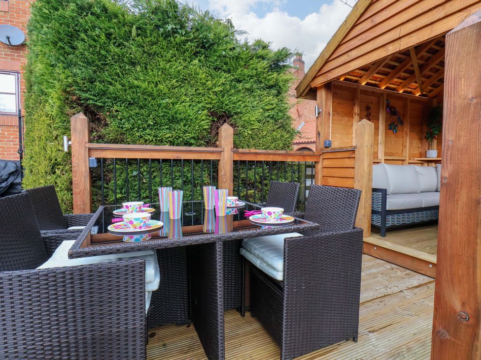 An outdoor dining area with wicker furniture at Eskview Cottage Ruswarp near Whitby