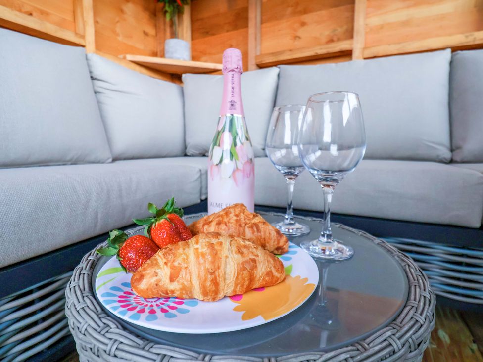 A table with croissants and strawberries beside glasses and a wine bottle at Eskview Cottage in Ruswarp near Whitby