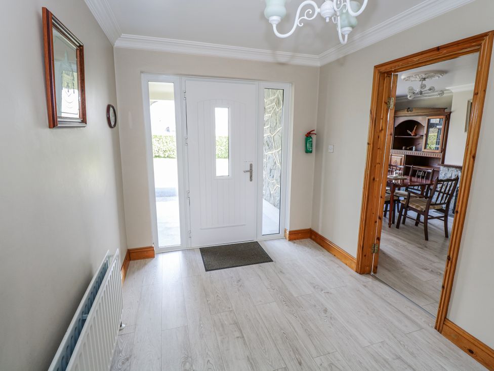 A hallway with a front door and a mirror at Castle View, Oughterard, County Galway