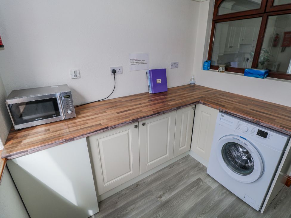 A laundry room with a microwave and washing machine at Castle View Oughterard, County Galway