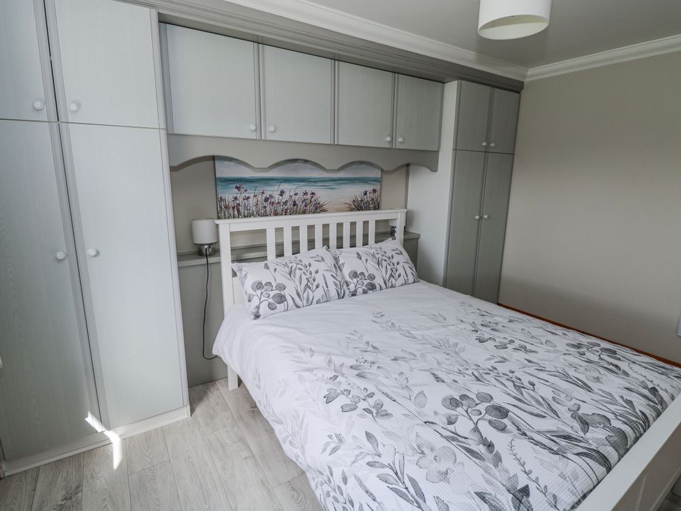 A bedroom with a bed and wardrobe at Castle View in Oughterard, County Galway