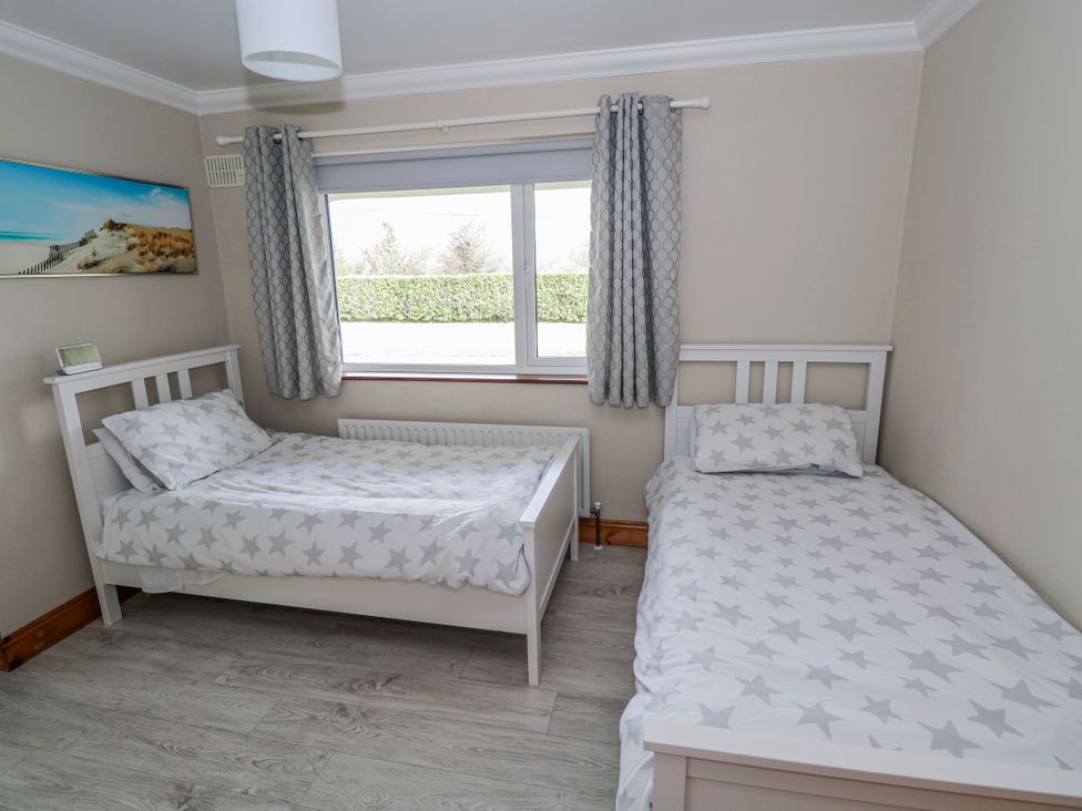 A bedroom with two beds and a window at Castle View, Oughterard, County Galway