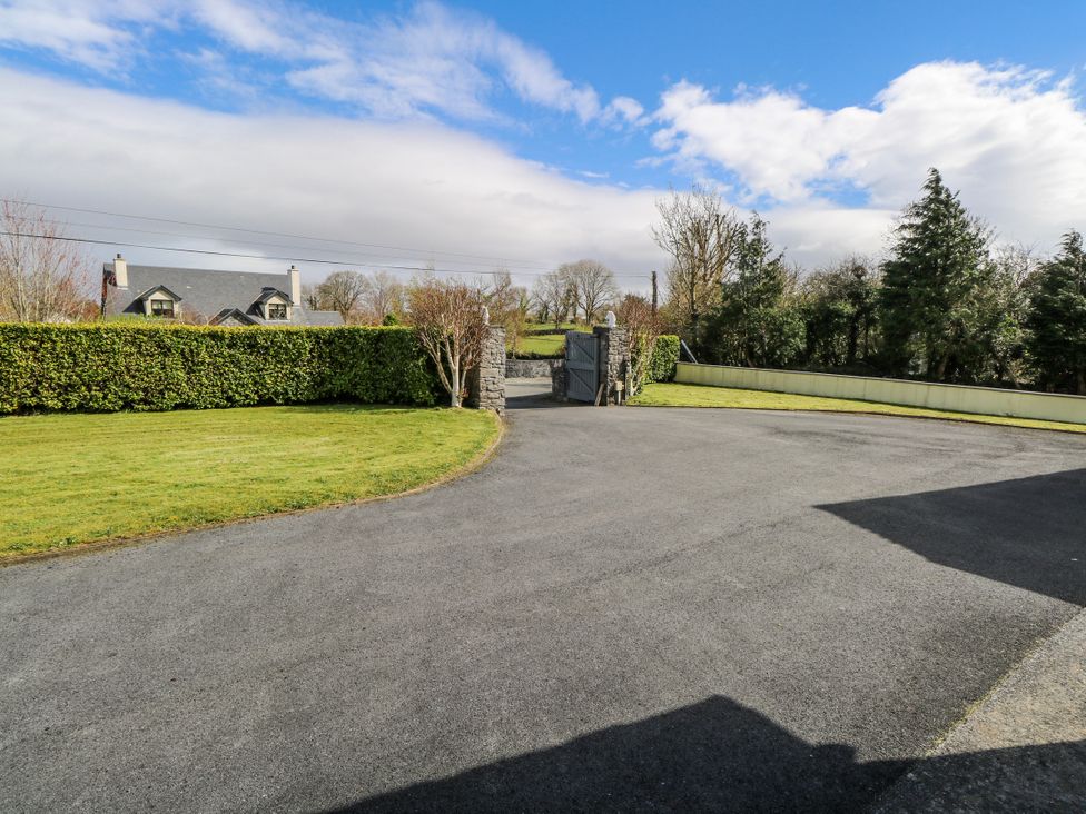 An outdoor area with a gate and house in the background at Castle View, Oughterard, County Galway