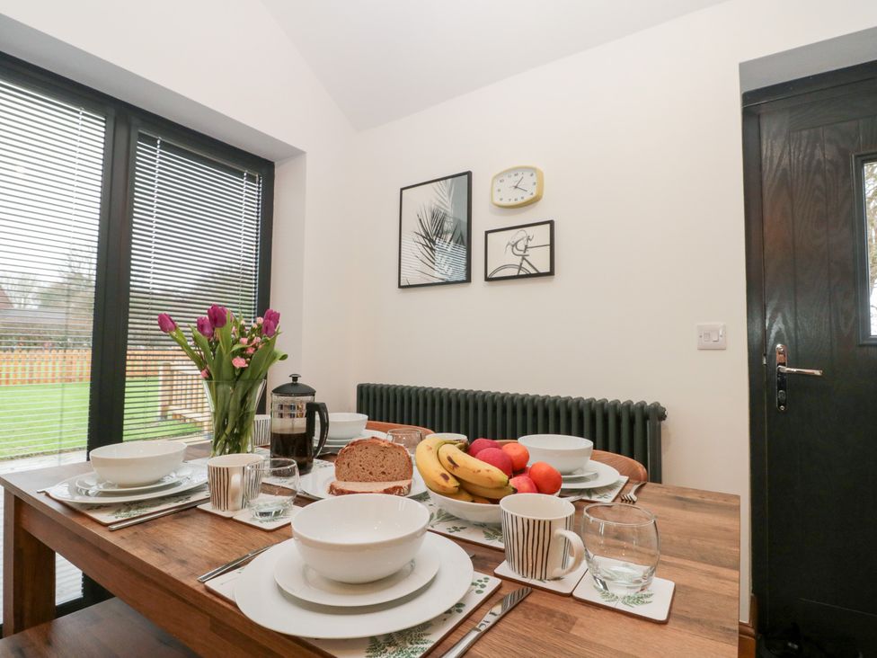 A dining room with a table set with fruit and dishes at Fieldside in Hunmanby