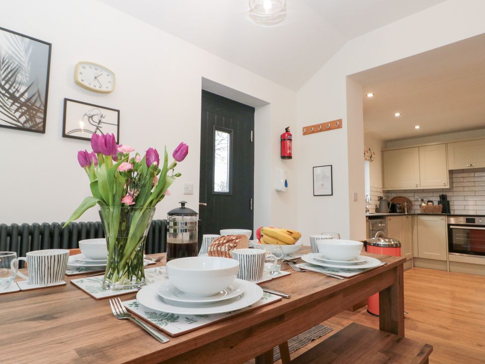 A dining room with a table set for a meal at Fieldside in Hunmanby