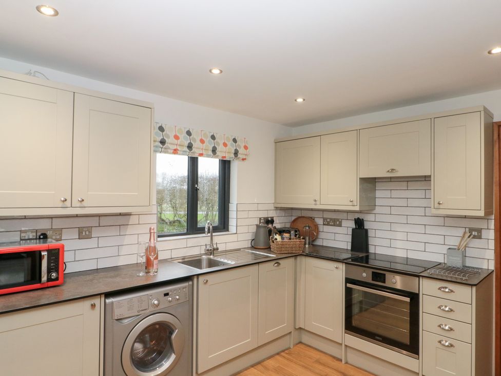 A kitchen with appliances and storage units at Fieldside in Hunmanby