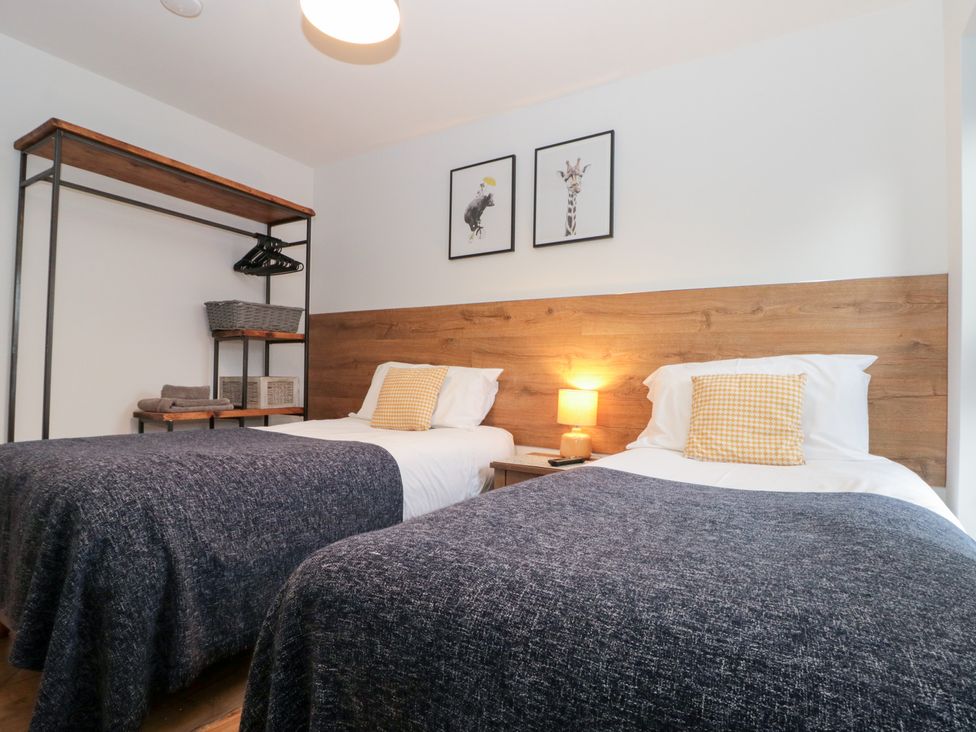 A bedroom with two beds and a shelf at Fieldside in Hunmanby