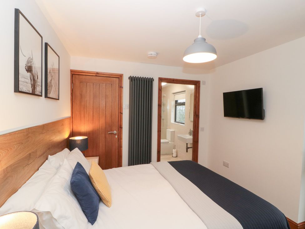 A bedroom with a bed and wall art at Fieldside in Hunmanby