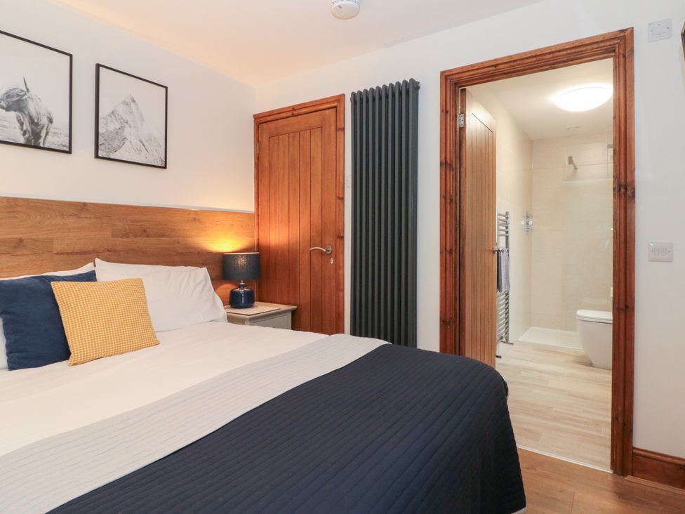 A bedroom with a bed and access to a bathroom at Fieldside in Hunmanby