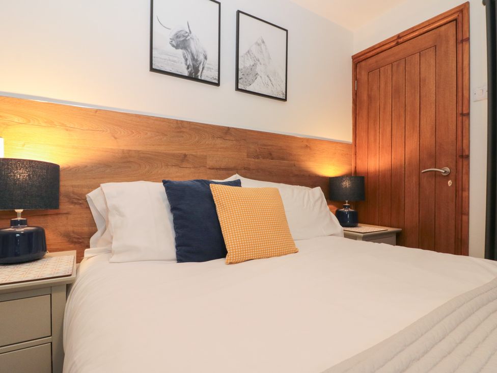 A bedroom with a bed and wall art at Fieldside in Hunmanby