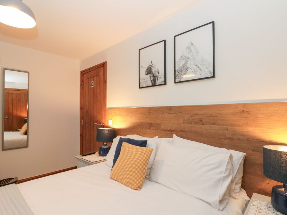 A bedroom with a bed and mirror at Fieldside Hunmanby