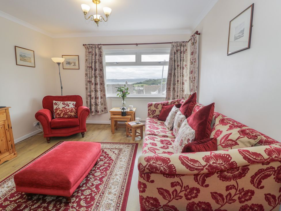 A living room with a sofa and armchair at Bay View in Benllech