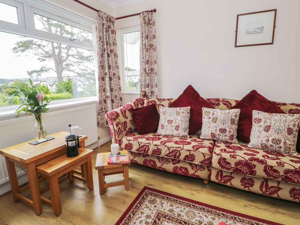 A living room with a floral sofa and coffee table at Bay View in Benllech
