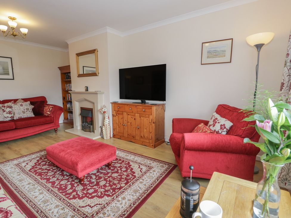 A living room with a television and seating at Bay View in Benllech