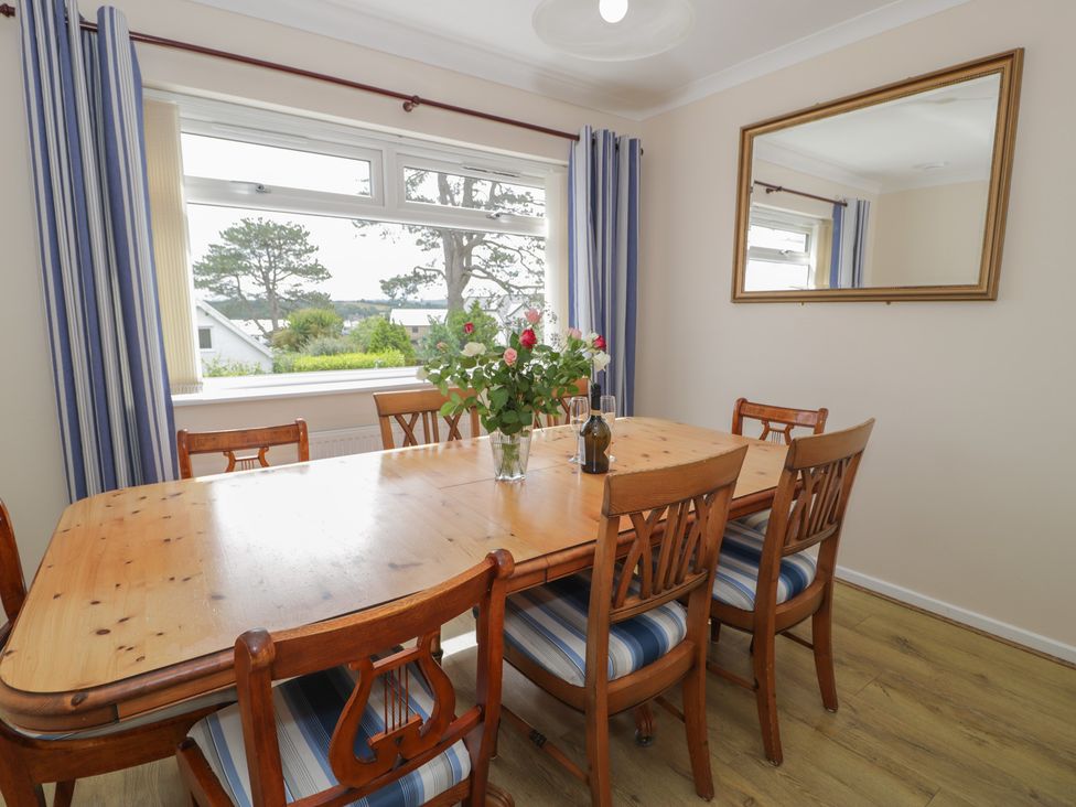 A dining room with a table and chairs at Bay View in Benllech