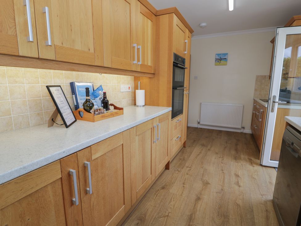 A kitchen with cabinets and countertop at Bay View in Benllech