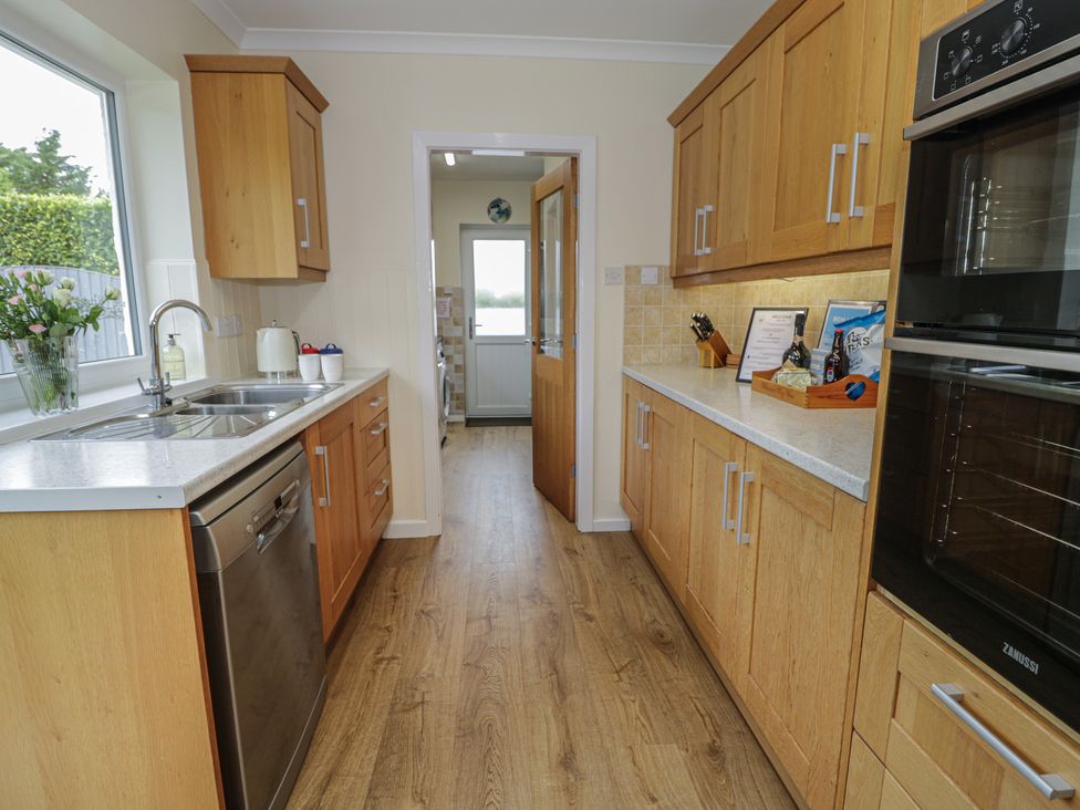A kitchen with cabinets and appliances at Bay View in Benllech