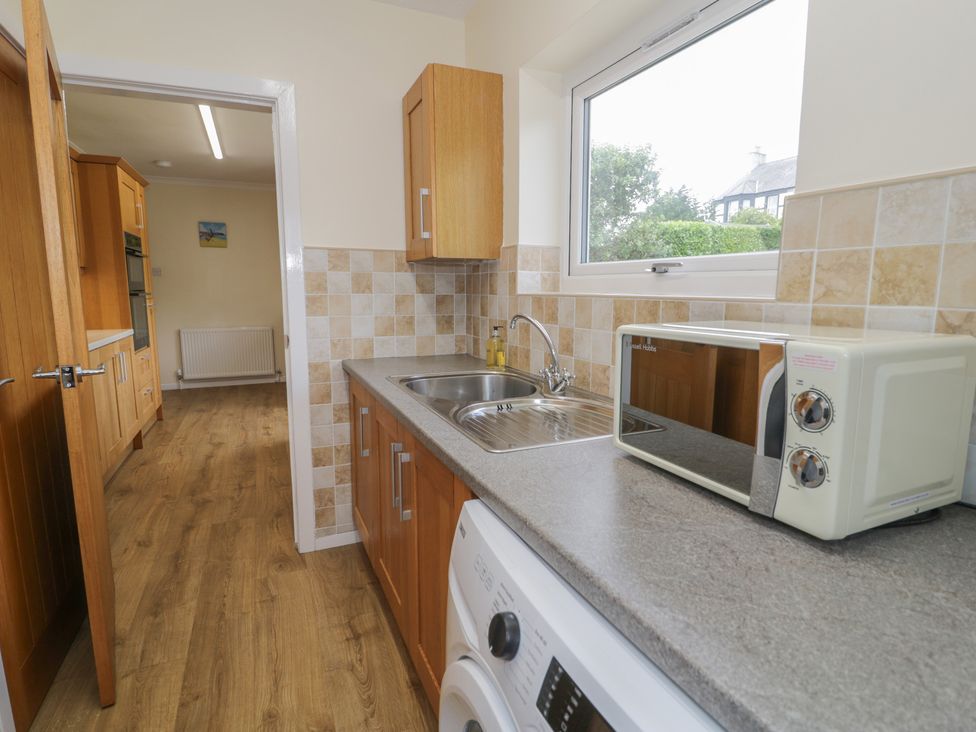 A kitchen with a sink and microwave at Bay View in Benllech