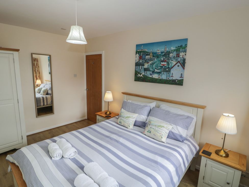 A bedroom with a bed and bedside tables at Bay View in Benllech