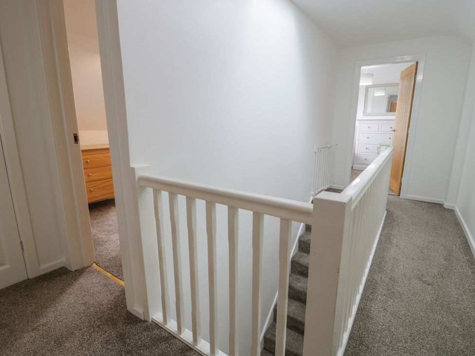 A hallway with a staircase and doors at Bay View in Benllech