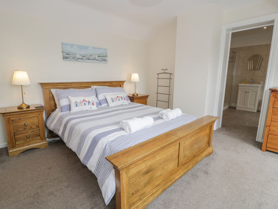 A bedroom with a bed and side tables at Bay View in Benllech
