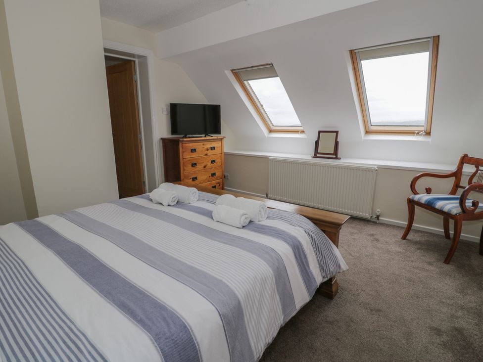 A bedroom with a bed and a TV at Bay View in Benllech