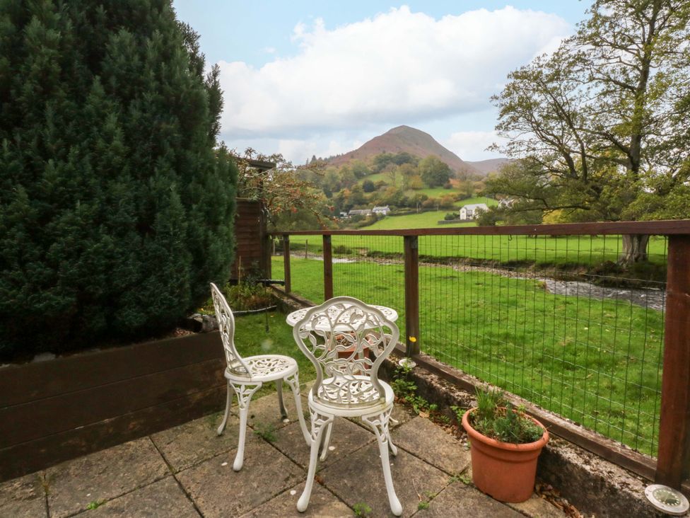 A garden with chairs and a view of a hill at River's Nook in Llangynog